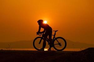 silueta de un ciclista al atardecer en tailandia. foto