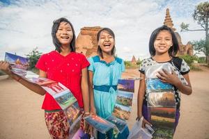 BAGAN, MYANMAR - OCT 11 2014 -  An unidentified girls sells postcard in old Bagan archaeology zone.