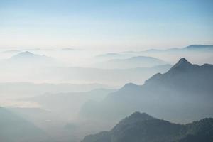 Scenery view of the mountains in the mist layer background. View from Phu Chi Fah in Chiang Rai province of Thailand. photo