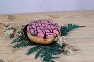 Brown donuts with sprinkles isolated on a wooden background photo