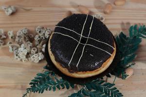 Brown donuts with sprinkles isolated on a wooden background photo