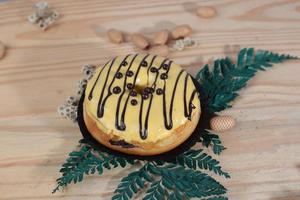 Brown donuts with sprinkles isolated on a wooden background photo