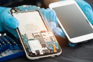 Technician repairing inside of mobile phone by soldering iron. Integrated Circuit. the concept of data, hardware, technology. photo