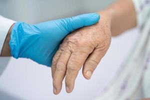 Doctor holding touching hands Asian senior or elderly old lady woman patient with love, care, helping, encourage and empathy at nursing hospital ward, healthy strong medical concept photo