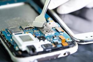 Technician repairing inside of smartphone, Integrated Circuit. the concept of data, hardware, technology.