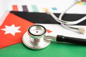 Black stethoscope on Jordan flag background with graph, Business and finance concept.