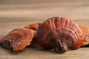 Dried lingzhi mushroom on wooden background, healthy herb food. photo