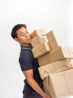 Young man carrying a box  of supplies to send a lot of customers carefully photo