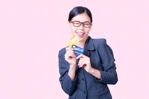 A beautiful Asian woman is happy and thinks that she will spend with many of her credit cards photo