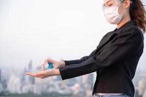 Asian women have to use masks  to protect against pollution from dust and prevent the infection from viruses spreading in the air with the introduction of preventive alcohol spray photo