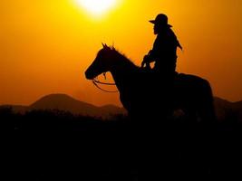Western cowboys are sitting on horseback under the sun and preparing to use guns to protect themselves in a land that is not yet legal photo