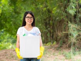Volunteer women collect plastic water bottles in the park area photo