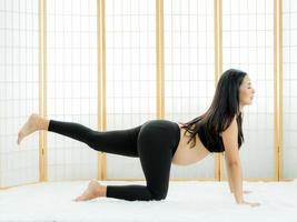 hermosas mujeres embarazadas en la habitación japonesa, relajan el cuerpo con ejercicios de yoga foto