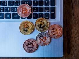 Los bitcoins son de cobre, oro y plata, que se encuentran en la moneda digital. sobre un fondo de teclado foto