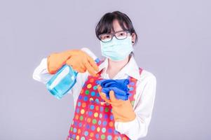 Asian women must use masks to prevent dust pollution and prevent infection from viruses that spread in the air by cleaning using alcohol spray photo