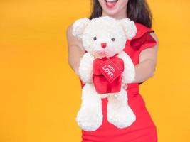 Beautiful Asian girl in red santa costume and bear of love on the celebration day photo