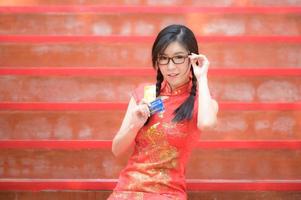 Asian woman in Chinese national costumes hold a credit card for shopping photo