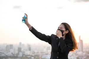Asian women have to use masks  to protect against pollution from dust and prevent the infection from viruses spreading in the air with the introduction of preventive alcohol spray photo