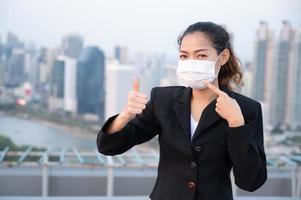 las mujeres de negocios asiáticas tienen que usar una máscara para cubrir la cara para evitar la contaminación del polvo foto