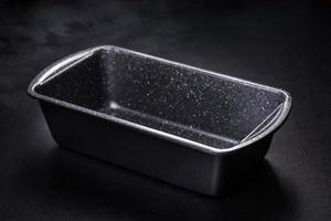 An empty ceramic grey baking dish on a dark concrete background photo