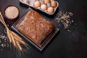 Beautiful tasty, square-shaped brown bread on a dark concrete background photo