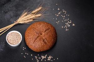 Fresh baked brown bread with ears and grains of wheat photo