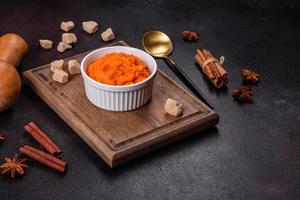 Pumpkin carrot baby puree in bowl on a dark background photo