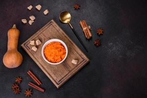 Pumpkin carrot baby puree in bowl on a dark background photo