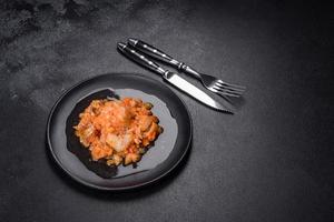 A delicious dish of hake fish in chunks in tomato sauce with spices and herbs photo