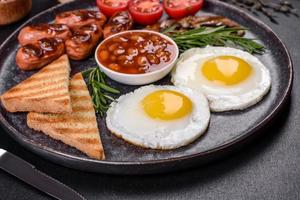 desayuno inglés completo con frijoles, huevos fritos, salchichas asadas, tomates y champiñones