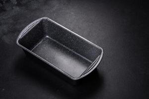 An empty ceramic grey baking dish on a dark concrete background photo