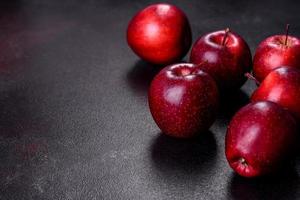 deliciosas manzanas frescas en rojo sobre un fondo de hormigón oscuro foto