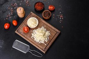 Image of a bar and grated mozzarella cheese on a dark background photo