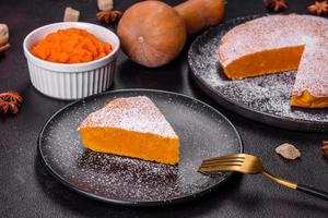 Pumpkin pie, tart made for Thanksgiving day with whipped cream on a black plate photo