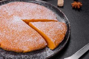 Pumpkin pie, tart made for Thanksgiving day with whipped cream on a black plate photo