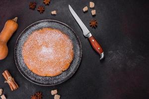 Pumpkin pie, tart made for Thanksgiving day with whipped cream on a black plate photo