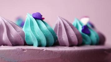 pastel de cumpleaños de color púrpura y verde sobre fondo de color video