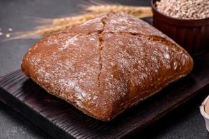 Beautiful tasty, square-shaped brown bread on a dark concrete background photo