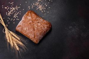 Beautiful tasty, square-shaped brown bread on a dark concrete background photo