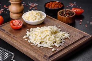 Image of a bar and grated mozzarella cheese on a dark background photo