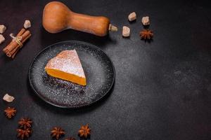 Pumpkin pie, tart made for Thanksgiving day with whipped cream on a black plate photo