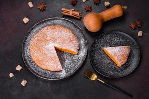 Pumpkin pie, tart made for Thanksgiving day with whipped cream on a black plate photo