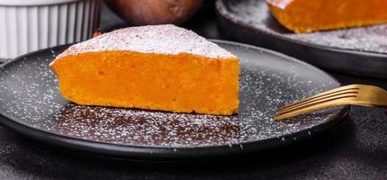 Pumpkin pie, tart made for Thanksgiving day with whipped cream on a black plate photo