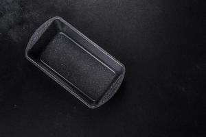 An empty ceramic grey baking dish on a dark concrete background photo