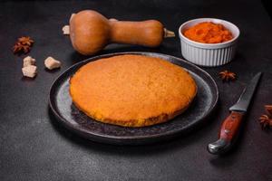 Pumpkin pie, tart made for Thanksgiving day with whipped cream on a black plate photo