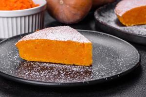 Pumpkin pie, tart made for Thanksgiving day with whipped cream on a black plate photo