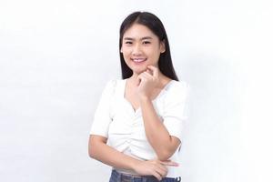 Portrait Asian beautiful girl in white shirt touches her face and smiles on white background studio. photo
