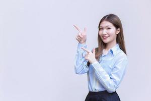 Asian professional business woman  who has long hair with a blue shirt smiles  present something on a white background.