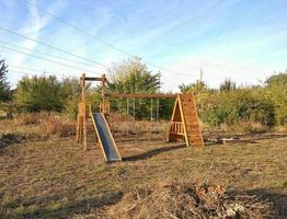 Wooden slide and swings for children for yard. photo
