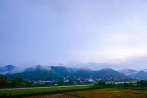 Lanscape of beautiful countryside of Samneua. sunrise morning. wonderful springtime landscape in mountains, foggy with house and road. grassy field and rolling hills. rural scenery. photo